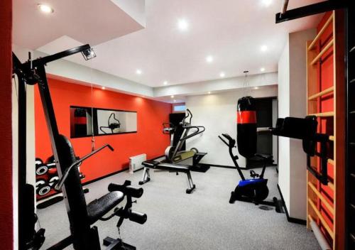 a gym with cardio equipment in a room with orange walls at Hotel SKI in Demanovska Dolina