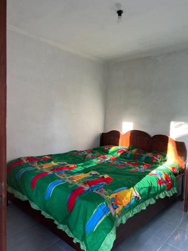 um quarto com uma cama com um edredão verde em Tetebatu Sunrise Homestay em Tetebatu