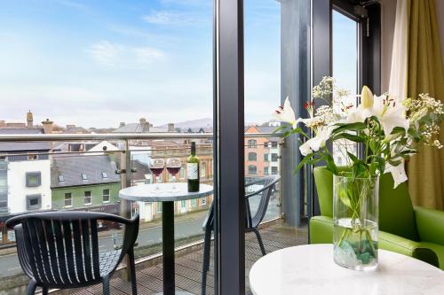 a balcony with a table with wine glasses and flowers at The Glasshouse in Sligo