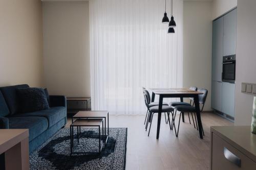 a living room with a couch and a table and chairs at Vesiroosi Apartments - Apartment 2 in Pärnu