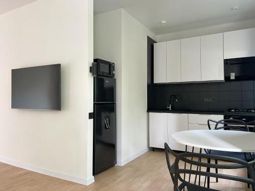 a kitchen with a black refrigerator and a table at Електрика 24 на 7 кондиціонер Bordo city center apartment двокімнатні апартаменти в центрі міста in Poltava