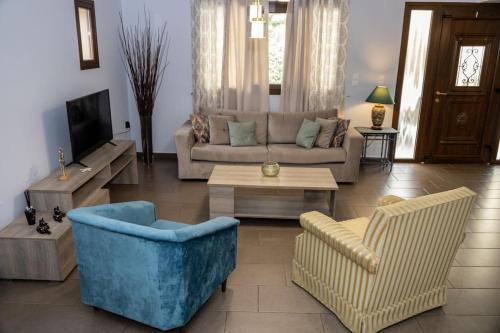 a living room with a couch and chairs and a tv at Sweet Home near Patras in Patra
