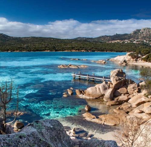 une grande masse d'eau avec des roches et de l'eau bleue dans l'établissement Casa Rosalina Sardinia Italy, à Luogosanto