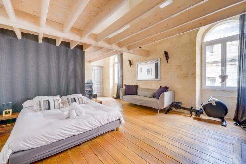 een grote slaapkamer met een bed en een bank bij Le 22 - Magnifique appartement en plein cœur des Chartrons in Bordeaux