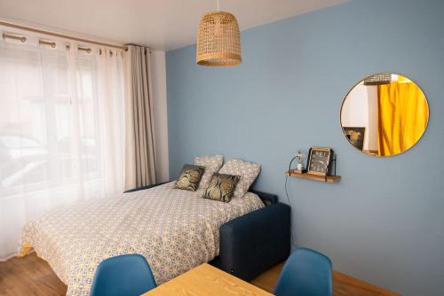 - une chambre dotée d'un lit avec des chaises bleues et un miroir dans l'établissement MAISON DIVISÉE EN 2 APPARTEMENTS POUR 8 PERSONNES, à Vermenton
