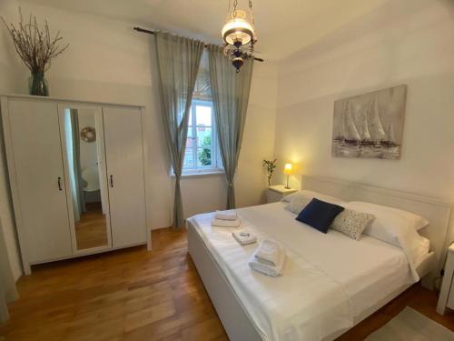 - une chambre avec un lit blanc et une fenêtre dans l'établissement Apartments Rafaela, à Korčula
