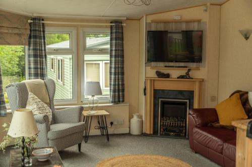 a living room with a couch and a fireplace at Treetops in Lamplugh