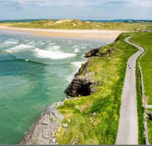 una carretera junto a una playa y el océano en Armada Cottages Bundoran, en Bundoran