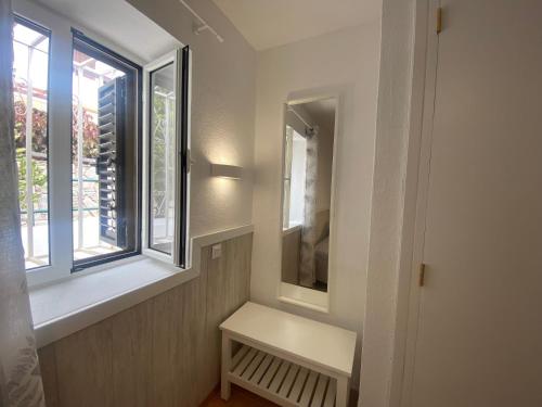 een kleine witte bank in een kamer met een raam bij Modern Duplex apartment near swimming pool in Mogán