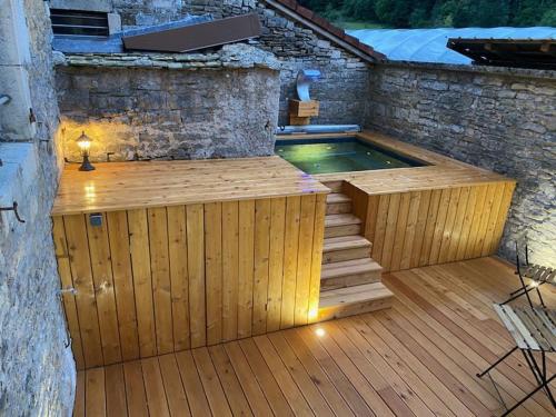 - Piscina con terraza de madera y bañera de hidromasaje en Gîte Les Muses, Ancien hôtel particulier avec SPA, en Ornans