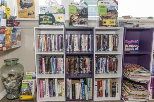 un estante de libros lleno de DVD en Greymouth Motel, en Greymouth