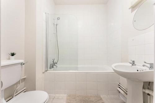 biała łazienka z wanną, toaletą i umywalką w obiekcie Stunning aparment in Canada Water w Londynie