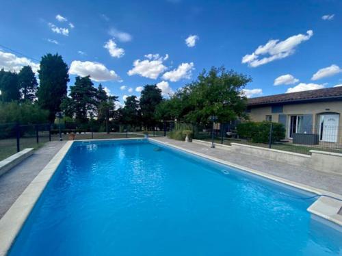 ein großer blauer Pool vor einem Haus in der Unterkunft L'Escale Lauragaise in Villefranche-de-Lauragais
