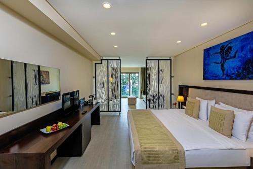 a hotel room with a large bed and a television at My Ella Bodrum Resort & Spa in Peksimet