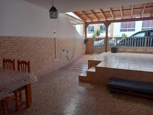 a room with a brick wall and a patio with a table at MyCasa in Morro del Jable