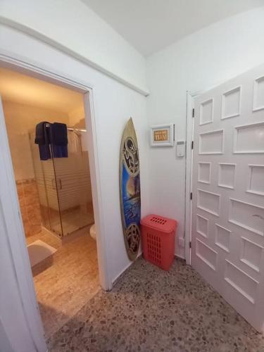 a bathroom with a door with a surfboard on the wall at MyCasa in Morro del Jable