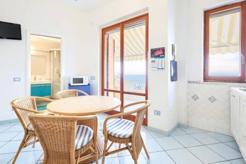 un tavolo con sedie in una cucina con vista sull'oceano di La Terrazza Amalfi ad Amalfi