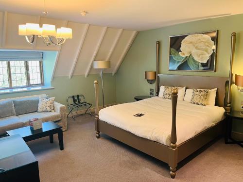 a bedroom with a bed and a couch in a room at Hogarths Stone Manor in Kidderminster