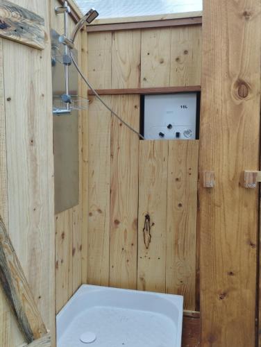 La salle de bains en bois est pourvue d'une baignoire et de toilettes. dans l'établissement La Roulotte romantique des volcans, à Saint-Saturnin