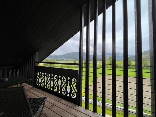a balcony with a large window with a view of a field at Hotel Krondlhof in Brunico