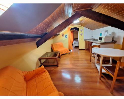 a living room with a couch and a table at Apartahotel portal de leon in Caboalles de Abajo