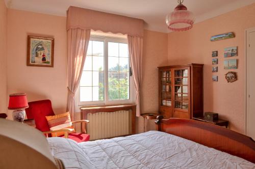 a bedroom with a bed and a window at Maison avec piscine pour 6 personnes in Plomeur