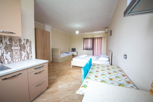 a room with a kitchen and a bedroom with a bed at Villa Gozhina in Durrës