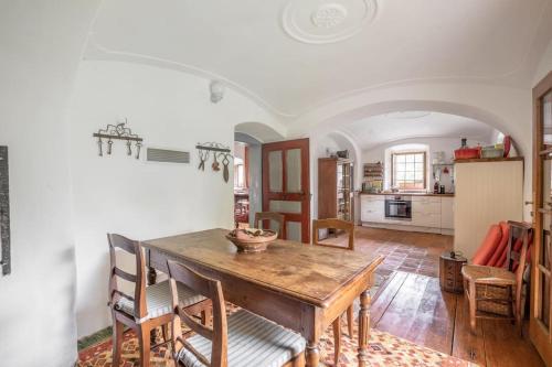 a kitchen and dining room with a wooden table and chairs at 18 century Bohemian Farmhouse in Hosterschlag