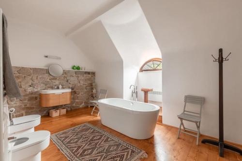 a bathroom with a white tub and a sink and a sink at 18 century Bohemian Farmhouse in Člunek
