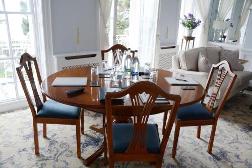 a dining room with a wooden table and chairs at Pier View Self Catering Luxury Apartments in Southend-on-Sea