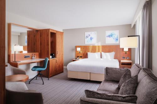 霍利的住宿－倫敦蓋特威克機場萬怡酒店，配有一张床和一张书桌的酒店客房