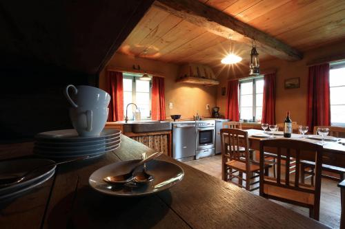 een keuken met een tafel met een bord erop bij Le Fournil de Hourt in Vielsalm