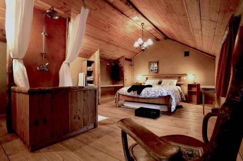 een slaapkamer met een bed en een houten plafond bij Le Fournil de Hourt in Vielsalm