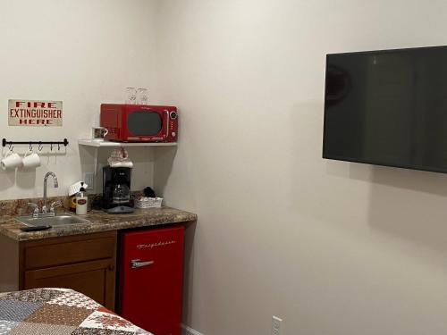 a kitchen with a tv on the wall and a sink at Hermann Crown Suites in Hermann