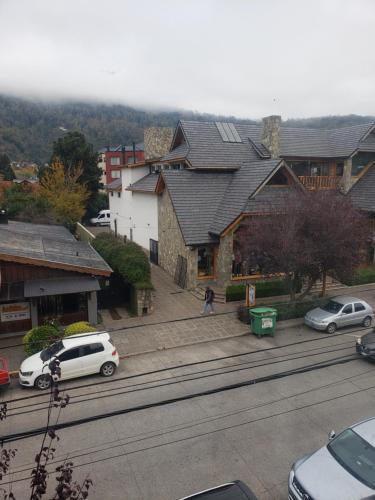 eine Gruppe von Autos, die vor den Gebäuden geparkt werden in der Unterkunft Para quedarse - SalePatagonia in San Martín de los Andes