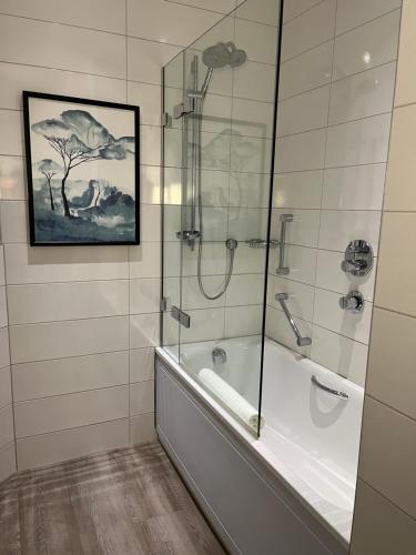 a bathroom with a shower and a bath tub at Hogarths Stone Manor in Kidderminster