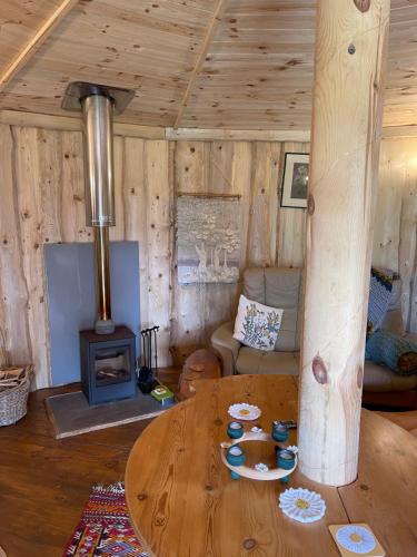 een woonkamer met een tafel en een houtkachel bij Acorn Glade Glamping in York