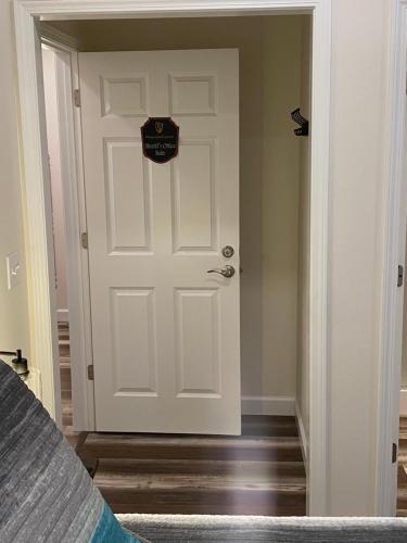 a white door with a sign on it next to a bed at Hermann Crown Suites in Hermann