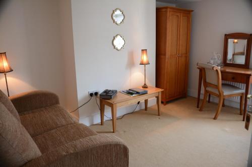 a living room with a couch and a table at Pier View Self Catering Luxury Apartments in Southend-on-Sea