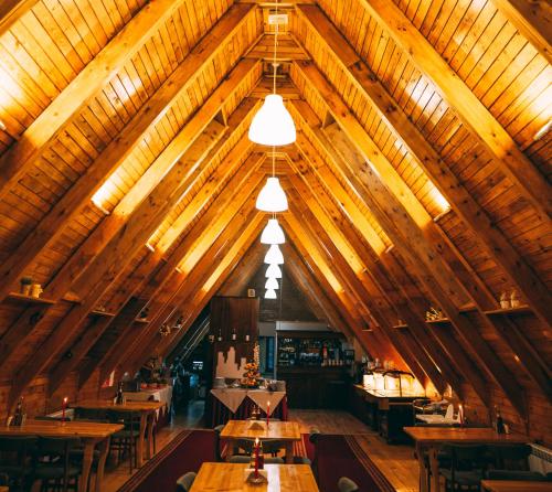 een eetkamer met houten tafels en houten plafonds bij Complex Malina Pamporovo in Pamporovo