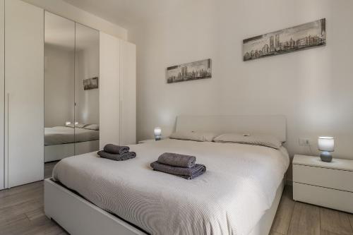 um quarto branco com uma cama com duas toalhas em Treviso to Venice - By Flora em Treviso
