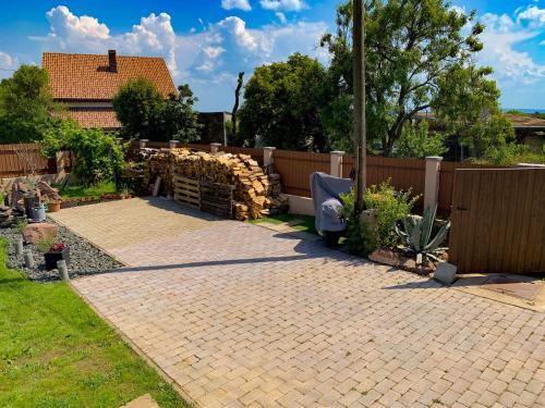 a backyard with a fence and a brick patio at Casamia4u in Alsóörs