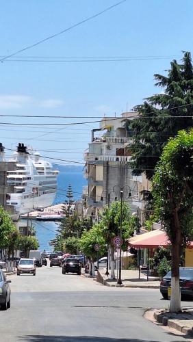 a cruise ship in the water next to a street at Hotel Qurku 2 in Sarandë