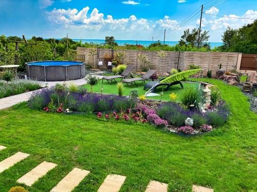 une arrière-cour avec un jardin fleuri et une piscine dans l'établissement Casamia4u, à Alsóörs