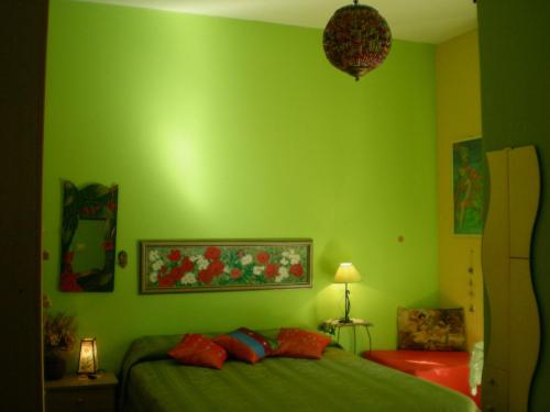 チェファルにあるOrizzonte B&Bの緑の壁の緑のベッドルーム(ベッド付)