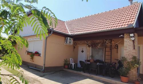 a house with a patio with a table and chairs at Bundik Vendégház in Berettyóújfalu