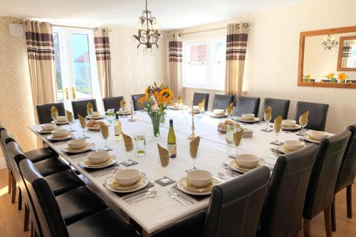 a large dining room table with chairs and a long table at Manor Farm Holiday Cottages in Reighton