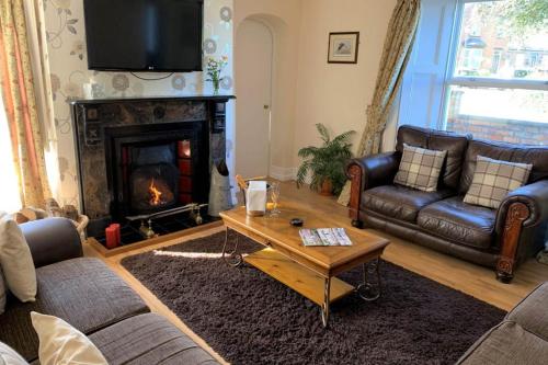 a living room with couches and a fire place at Manor Farm Holiday Cottages in Reighton