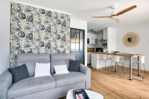 un salon avec un canapé et une cuisine dans l'établissement Les Ebihens - Studio et chambre indépendante, à Saint-Cast-le-Guildo