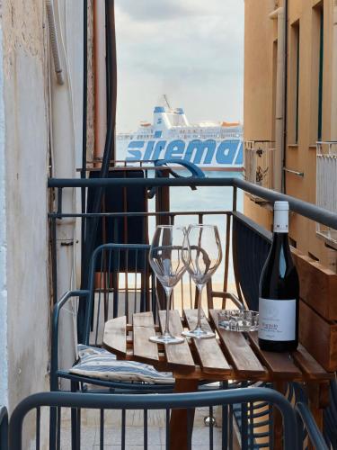 a table with glasses and a bottle of wine on a balcony at I Normanni in Trapani